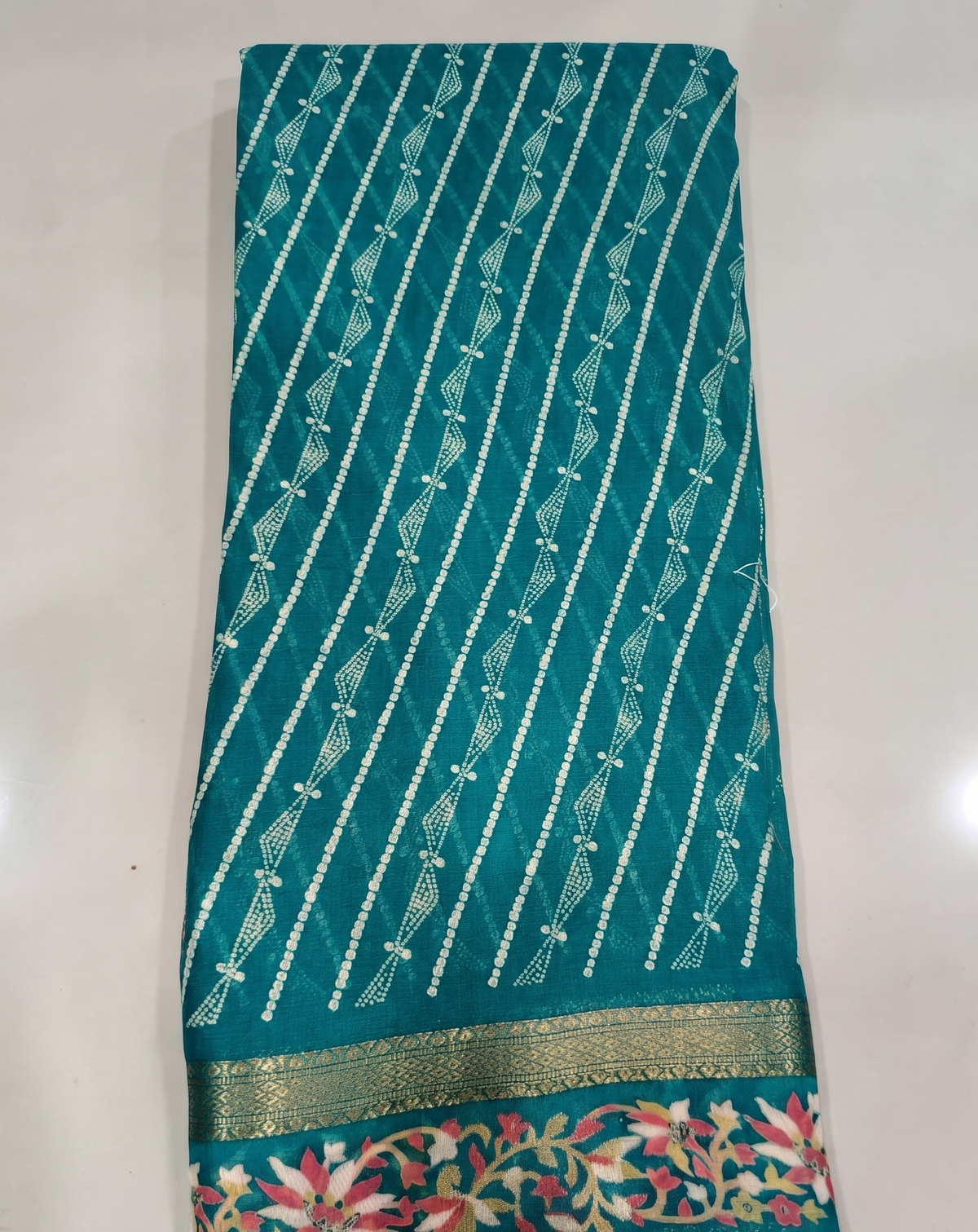 Teal saree with diagonal stripes and colourful floral border